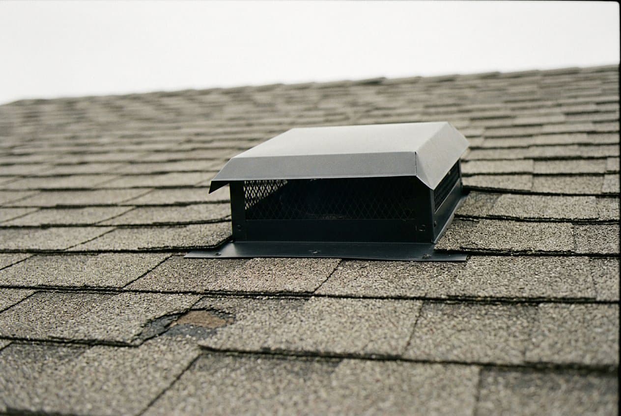 New black vent cap installed on shingles